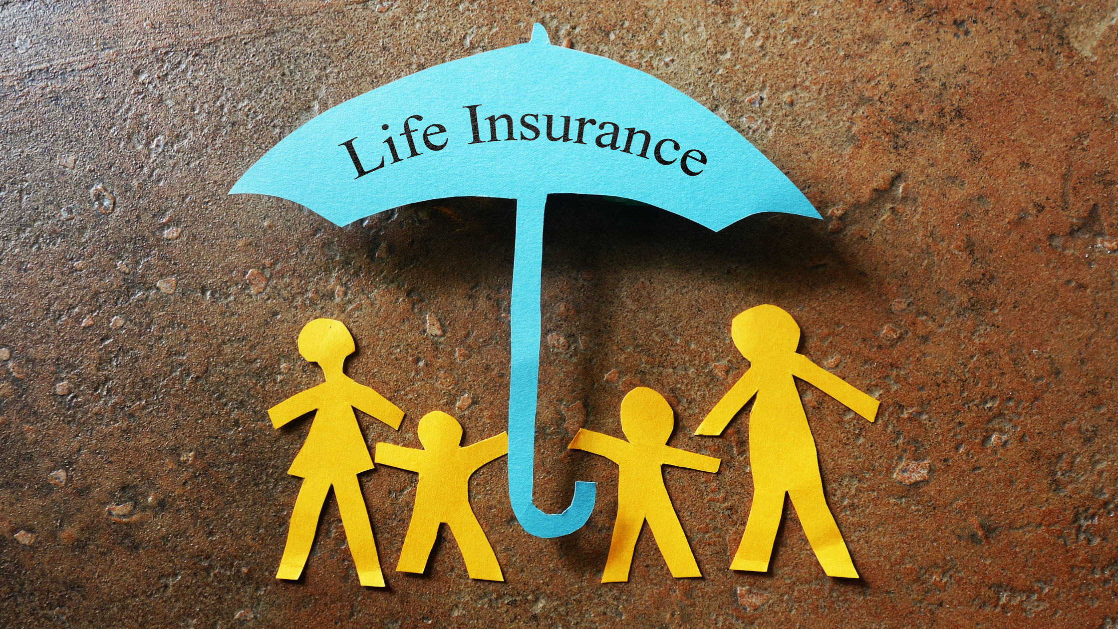 paper cut-out of family with umbrella displaying "life insurance"